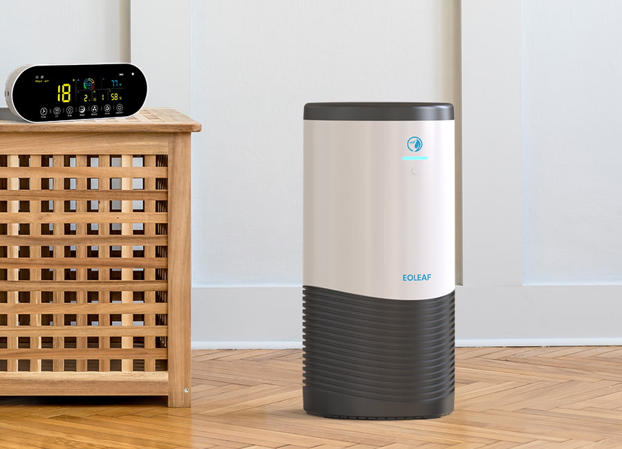 Eoleaf's AEROPRO 100 air purifier in a white room with its remote control terminal on wood furniture