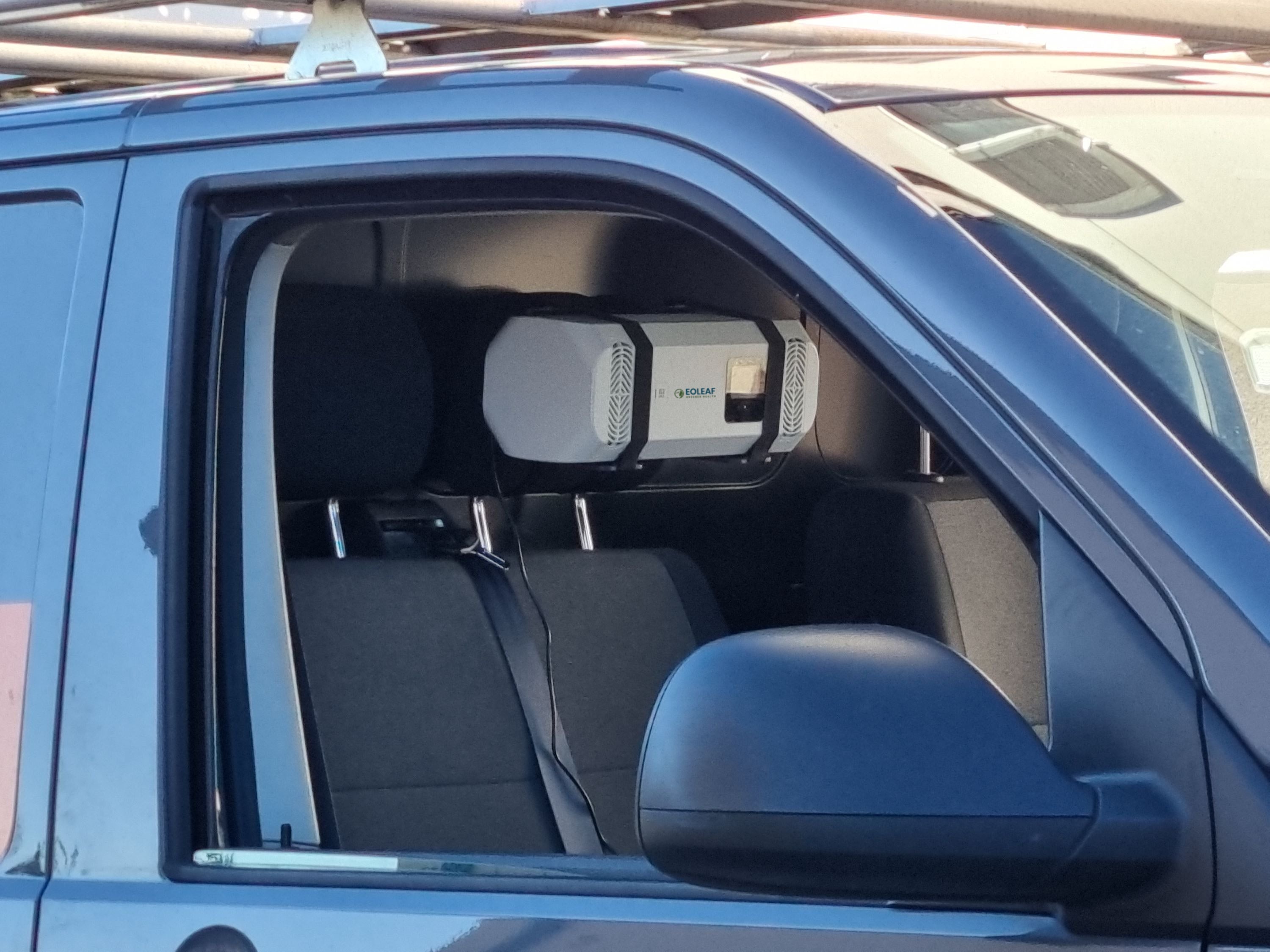 Eoleaf's Pure CAR air purifier attached to a headrest in a blue car