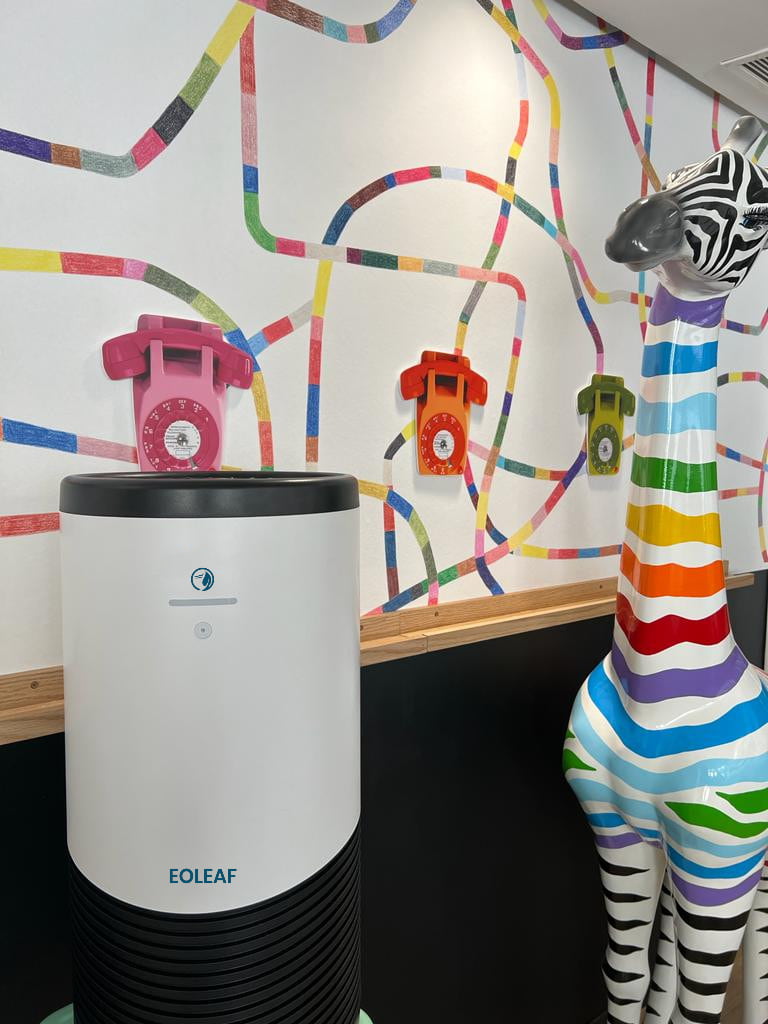 Eoleaf's AEROPRO 100 air purifier in an office next to a colourful plastic giraffe