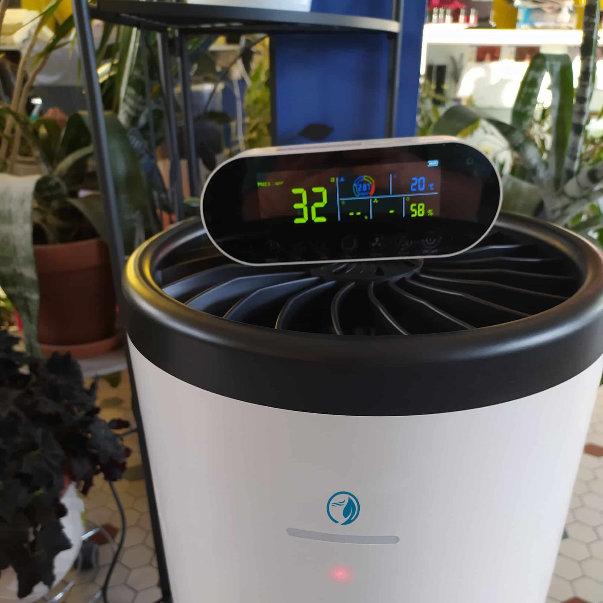 Eoleaf's AEROPRO 100 air purifier and its remote control terminal in a shop with many plants