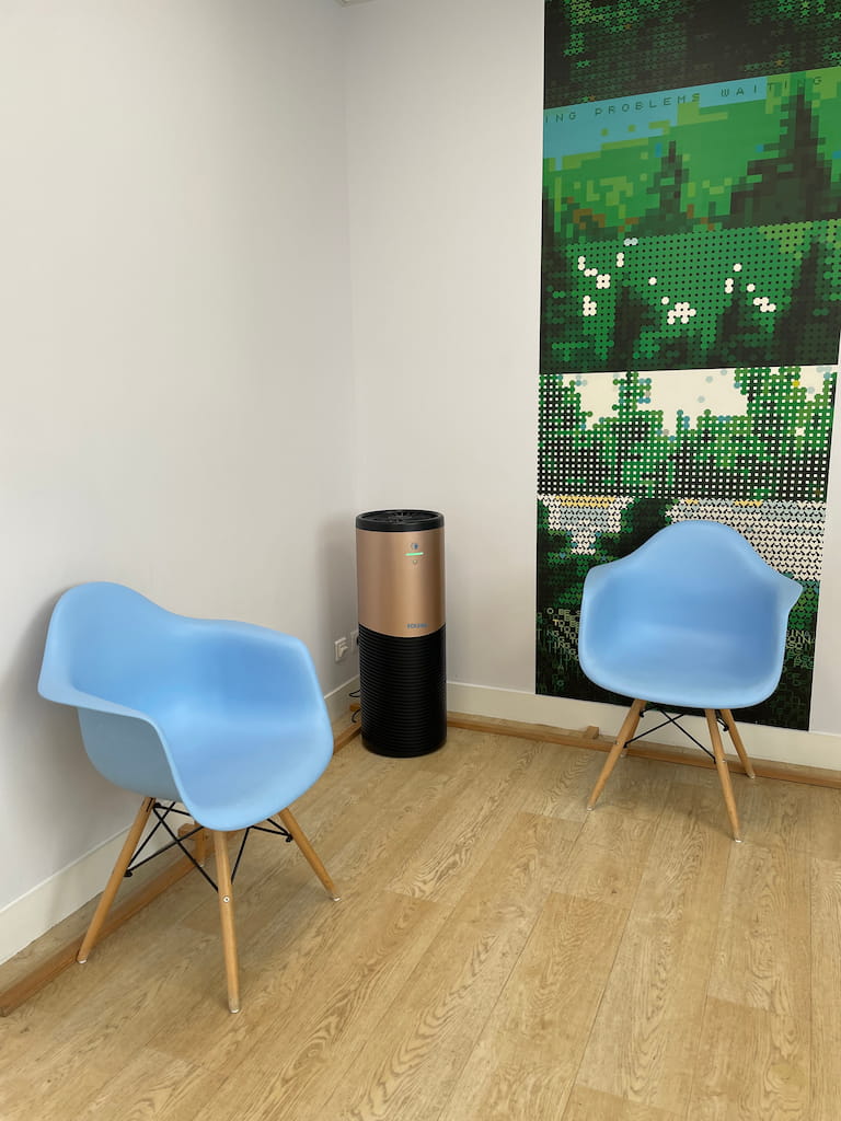 Eoleaf's AEROPRO 150 air purifier in a medical waiting room next to blue chairs